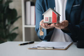 The salesperson of the housing estate in the project is preparing and verifying the contract of...