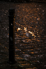 Obraz premium parking pole during a heavy snowfall nothing in the city on a cobbled street