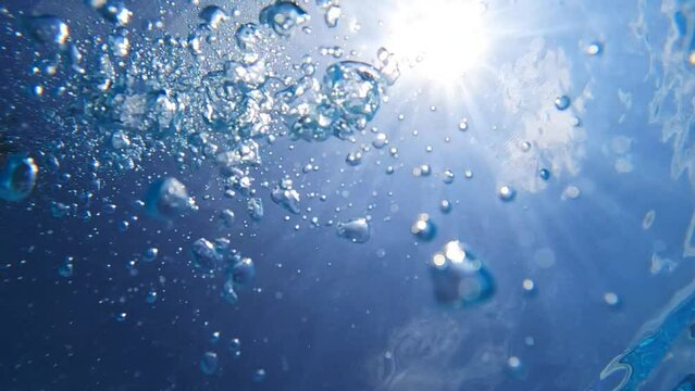 Underwater slow motion video of deep blue air bubbles released in jacuzzi spa creating perfect relaxing treatment for well being
