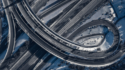 Aerial view of a freeway intersection Snow-covered in winter.Busy intersection. Birds eye view from drone. Cityscape