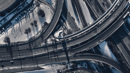 Aerial view of a freeway intersection Snow-covered in winter.Busy intersection. Birds eye view from drone. Cityscape