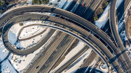 Aerial view of a freeway intersection Snow-covered in winter.Busy intersection. Birds eye view from drone. Cityscape