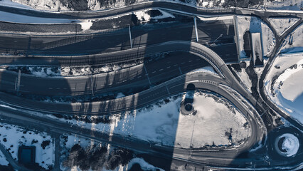 Aerial view of a freeway intersection Snow-covered in winter.Busy intersection. Birds eye view from drone. Cityscape