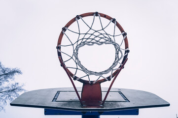 Basketball hoop with net on sky background