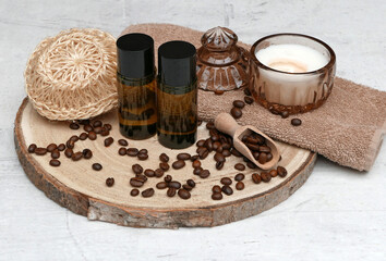Natural care with coffee: coffee beans with towel, candle, shampoo and exfoliating sponge.