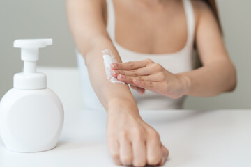 Body skin care routine concept. Close-up view hands of a young woman applying lotion cream on the hand