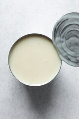 An opened tin of condensed milk, with the lid