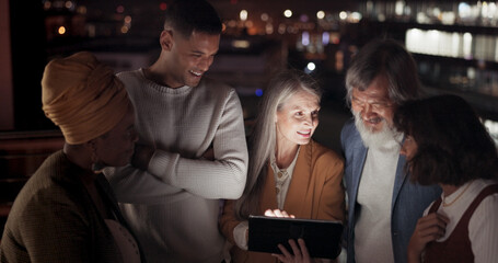 Tablet, collaboration and night with a business team working together in the city on their office balcony. Finance, teamwork and meeting with a man and woman employee group talking strategy outside