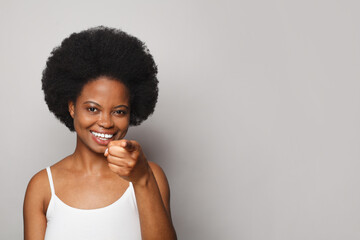 Attractive cheerful woman smiling and pointing finger at camera