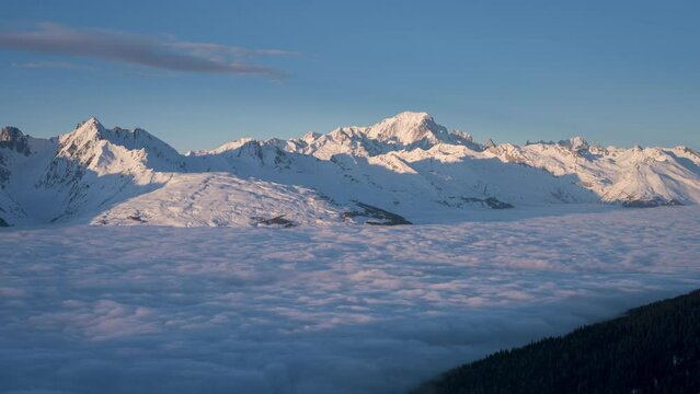 Time lapse of cloud inversion and Mont Blanc at distance during sunset viewed from La Plagne ski resort. Day to night transition