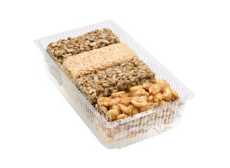 Kozinaki in a plastic container isolated on a white background.The Traditional Sweetness of Southwest Asia.