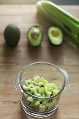 Glass jar with raw chopped celery, avocado and apple, ingridients for health green organic smoothie. Vegan diet and nutrition, healthy detox, alkaline food, vegetarian concepts drinks