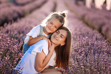 Happy family in purple lavender field. young beautiful mother and child Girl enjoy walking blooming...