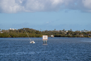 Fototapeta na wymiar Sunken boat beside a caution shoal area sign