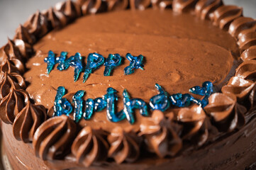 Colorful happy birthday cake with sprinkles and decor on a white background