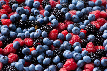 close up view of fresh ripe mixed Blueberries, blackberries and raspberries as flatlay background
