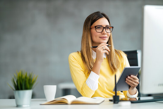 Young female designer using graphics tablet while working with computer