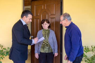 Image of a sales rep and door-to-door salesman explaining his products for sale to an older couple. Harassing seller and scammer.

