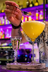 man hand bartender pouring cocktail in glass on the bar counter