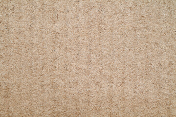 Fototapeta na wymiar Cardboard surface, beige paper small, rough background of recycled waste paper, close-up macro view, uniform texture pattern.