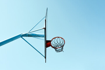 old abandoned street basketball hoop and blue sky background