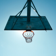 old abandoned street basketball hoop and blue sky background © Ismael