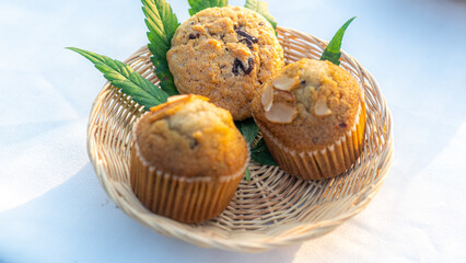 Marijuana chocolate cupcake muffins with weed cbd. Medical marijuana hemp drugs in food dessert. Weed muffins with cannabis, milk chocolate and cannabis leaves served on plate white table