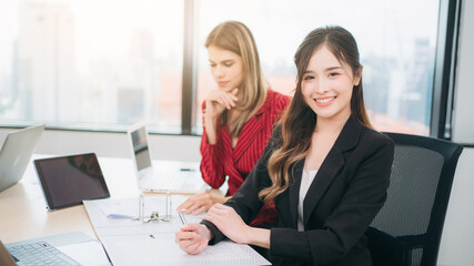 Portrait of happy Business looking camera and people converse during a meeting about papers and concepts. .
