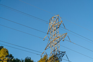  High voltage electrical pylons against blue sky