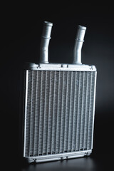 Aluminum new heater core. Car parts on a black background