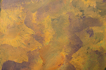 Orange and purple colors smudged on leather texture, abstract autumn backdrop,