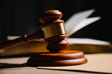 Justice and law concept.Male judge in a courtroom with the gavel, working with, computer and docking keyboard, eyeglasses, on table in morning light