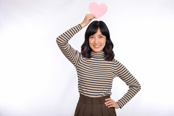 Beautiful young asian woman holding a paper heart while standing against white background. Beautiful young asian woman with paper heart.
