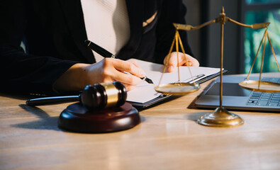 Justice and law concept.Male judge in a courtroom with the gavel, working with, computer and...
