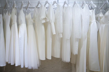 Different wedding dresses on hangers in boutique