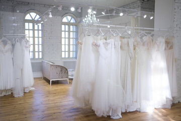 Fototapeta na wymiar Different wedding dresses on hangers in boutique