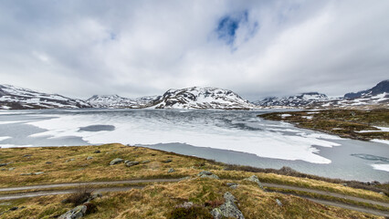 Beautiful mountain landscape in Norway with ice shelfs on a mountain lake