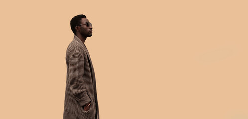 Fashionable portrait of stylish african man model looking away wearing knitted cardigan isolated on...