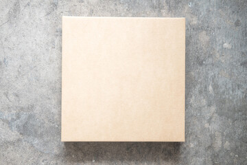 Closed blank cardboard box on a cement background. Top view. Delivery concept