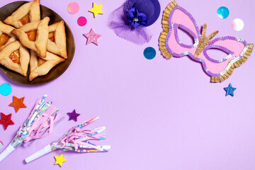 Purim carnival background with traditional cookies, costume accessories and decor on pastel violet