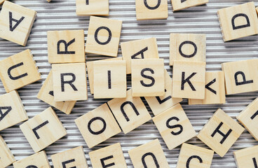 Word Risk surrounded by scattered wooden blocks with letters