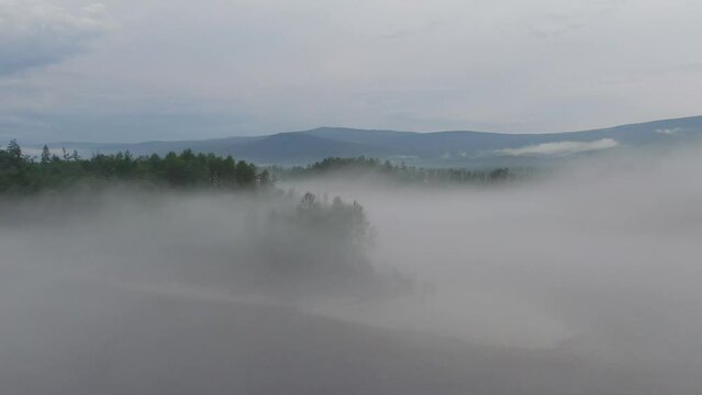 Misty early winter morning at lake where water evaporates creating dangerous fog