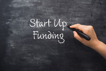 Person points to phrase Start Up Funding on blackboard