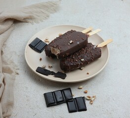 two chocolate popsicles on a plate