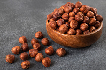 View of a bowl full of hazelnuts on a black background
