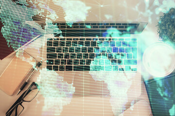 Obraz premium Business theme hologram drawings over computer on the desktop background. Top view. Multi exposure. Concept of international connections.