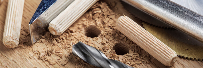 drill bit makes hole in wooden oak board for wooden dowel.