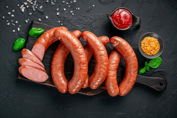 Smoked sausages in vacuum packaging. On a black background.