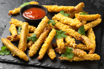Fried Vegan jackfruit and oyster prawns in crispy batter served on black slate with chili dip sauce