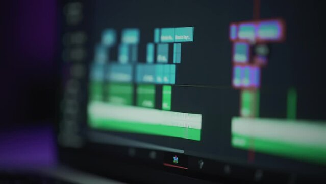 A human editor uses a laptop to creatively create a video clip. Makes color correction of video content. A freelance colorist works at home in the studio. The cinematographer is editing the film